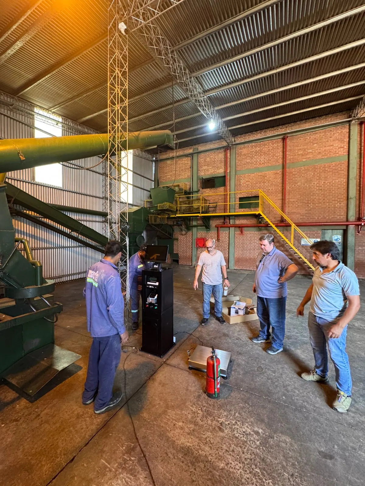 Equipo revisando instalación de balanza y puesto operativo dentro de una planta industrial